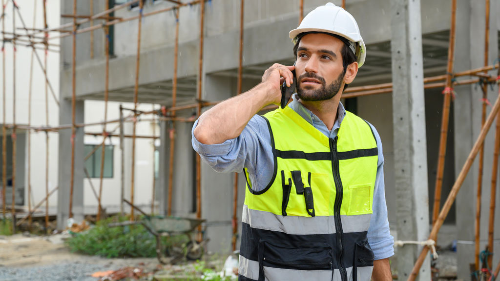 Personne au téléphone discutant de garanties construction dans un bureau